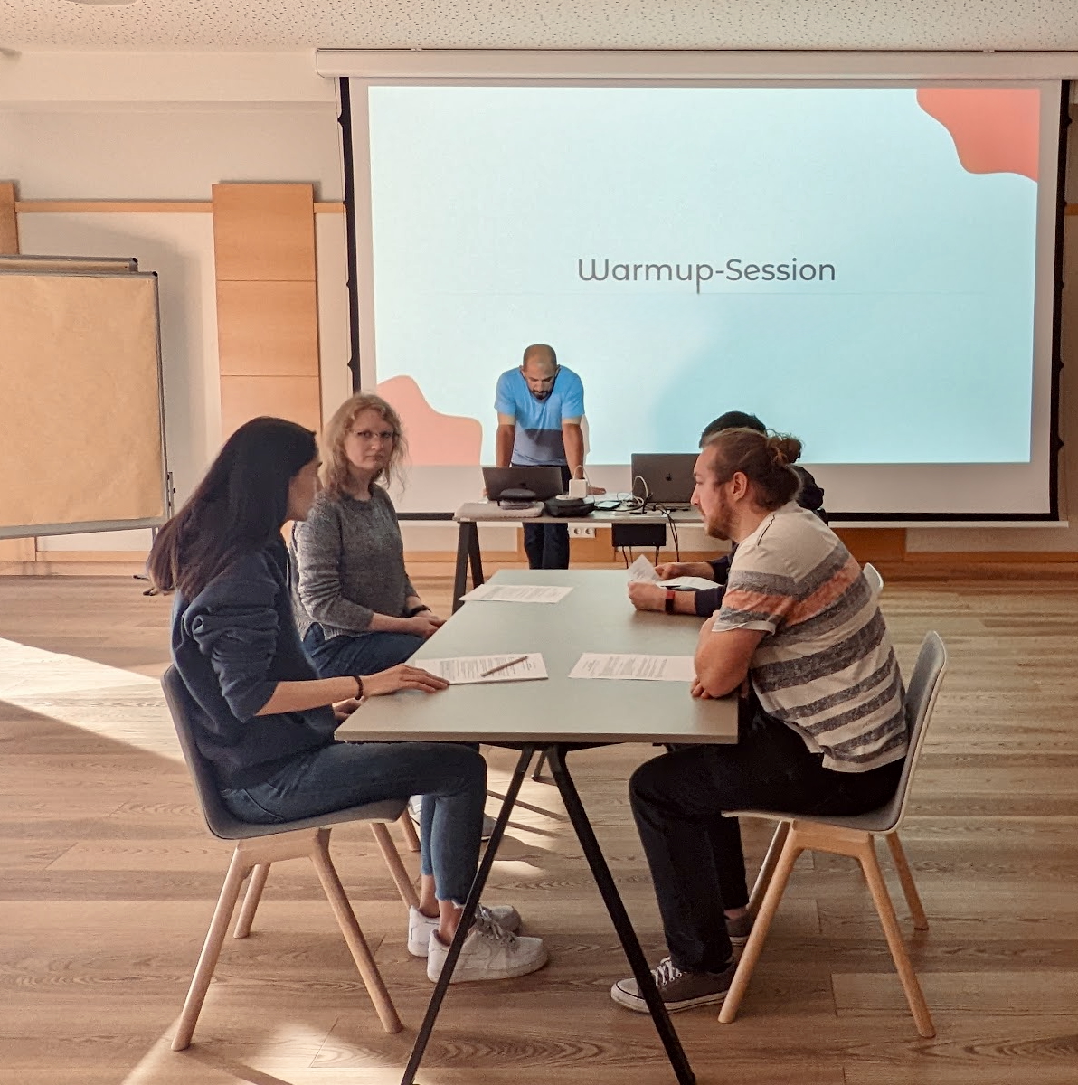 vier personen sitzen an einem Tisch